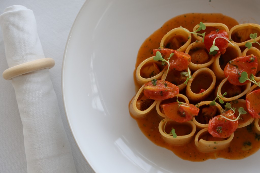 Piatto di pasta gourmet con salsa cremosa, pomodorini e microgreens